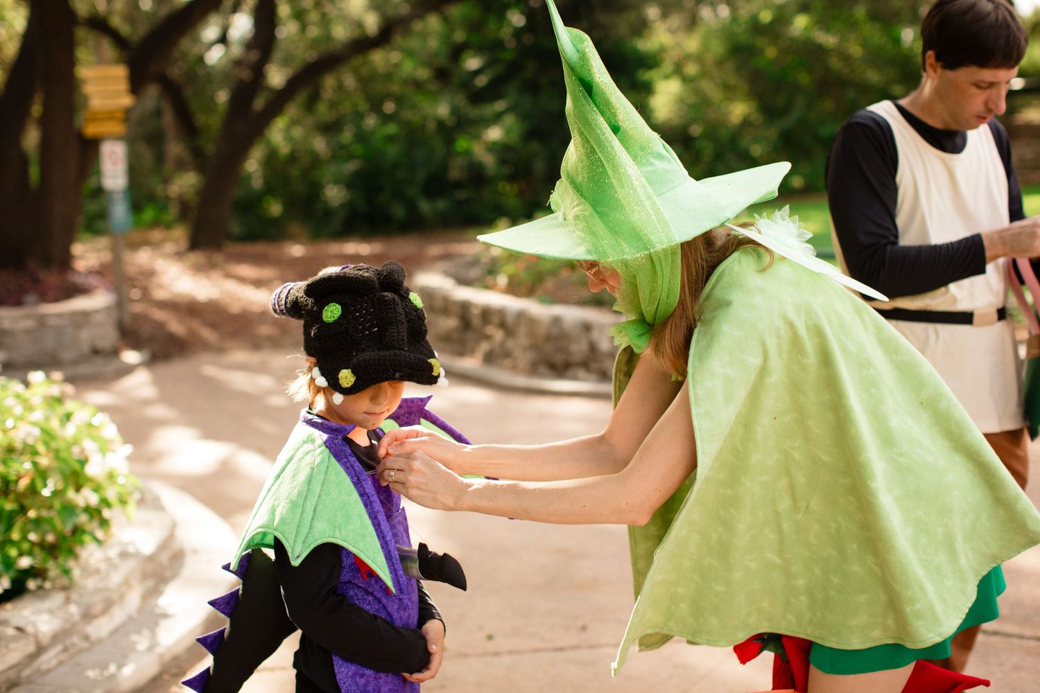 Mother adjusts her sons costume at a family photo shoot at Zilker Botanical Gardens