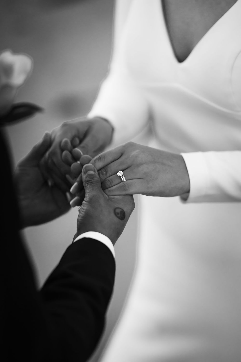 A series of black and white close-up shots showing hands exchanging wedding rings during a marriage ceremony.