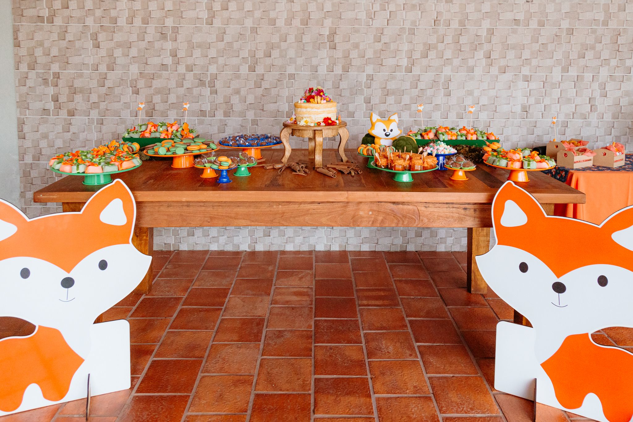 A series of decorative paper fox masks hung on a brick wall with twine in a festive party display.
