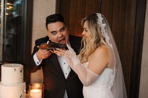 A couple shares an intimate moment during their wedding reception at a dimly lit venue with candles.