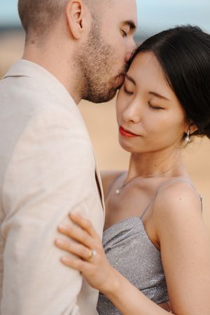 A romantic couple sharing intimate moments in a series of close-up shots wearing grey and white attire.