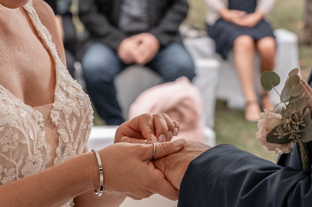 A series of wedding ring detail shots showing hands exchanging and holding rings during a ceremony.