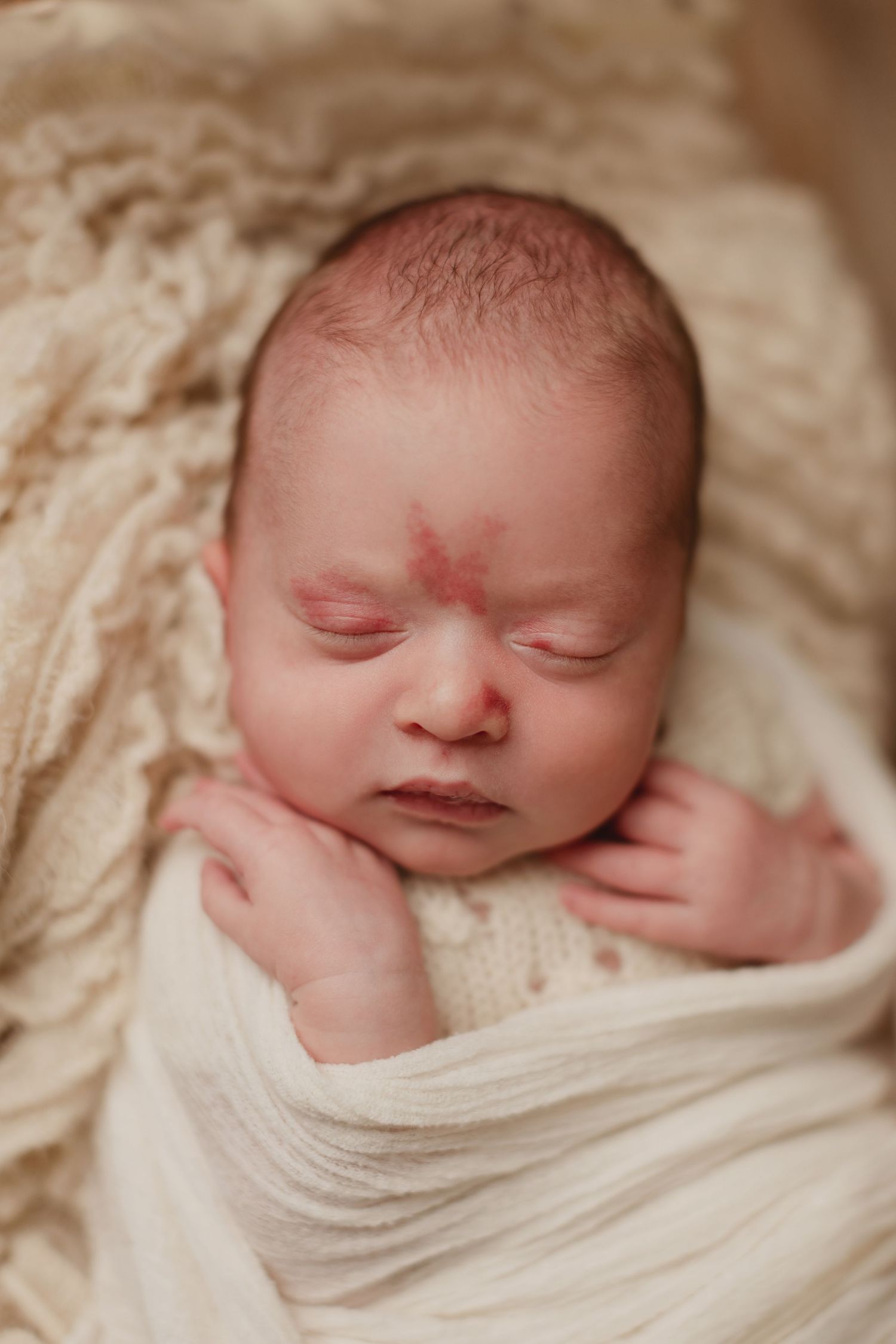 A series of peaceful newborn portraits showing a sleeping baby wrapped in soft white fabric.