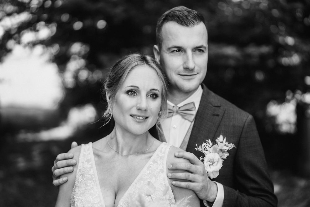 Black and white portrait of newlyweds in romantic outdoor setting.