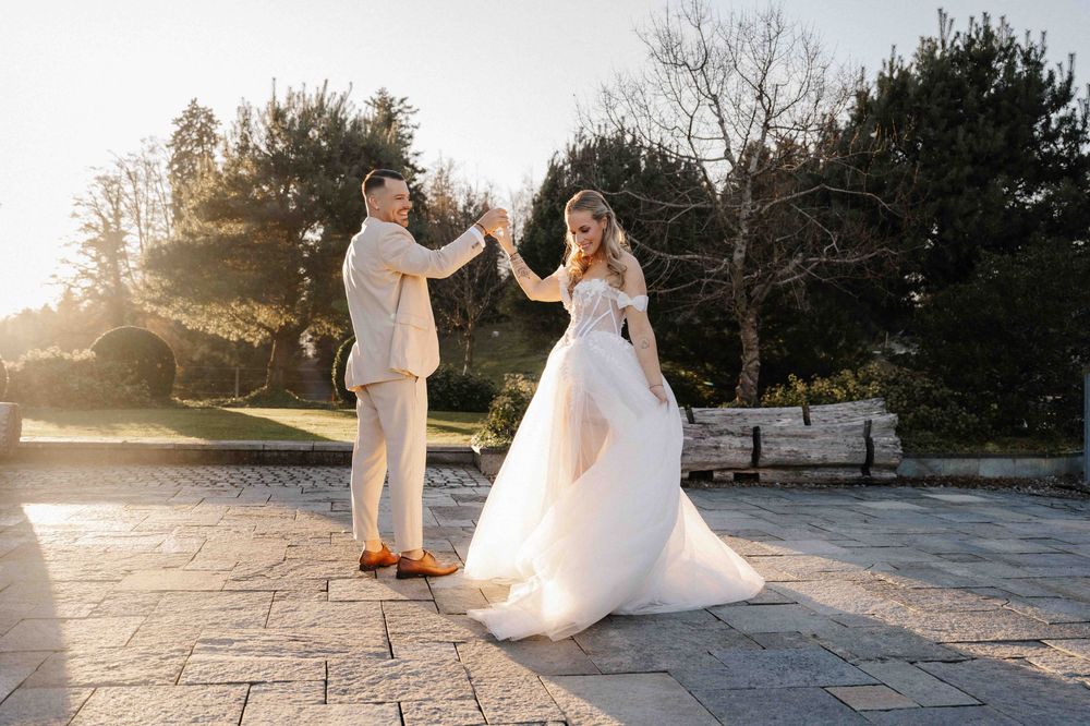 A romantic sunset wedding photoshoot with a couple dancing on a stone patio in golden light.