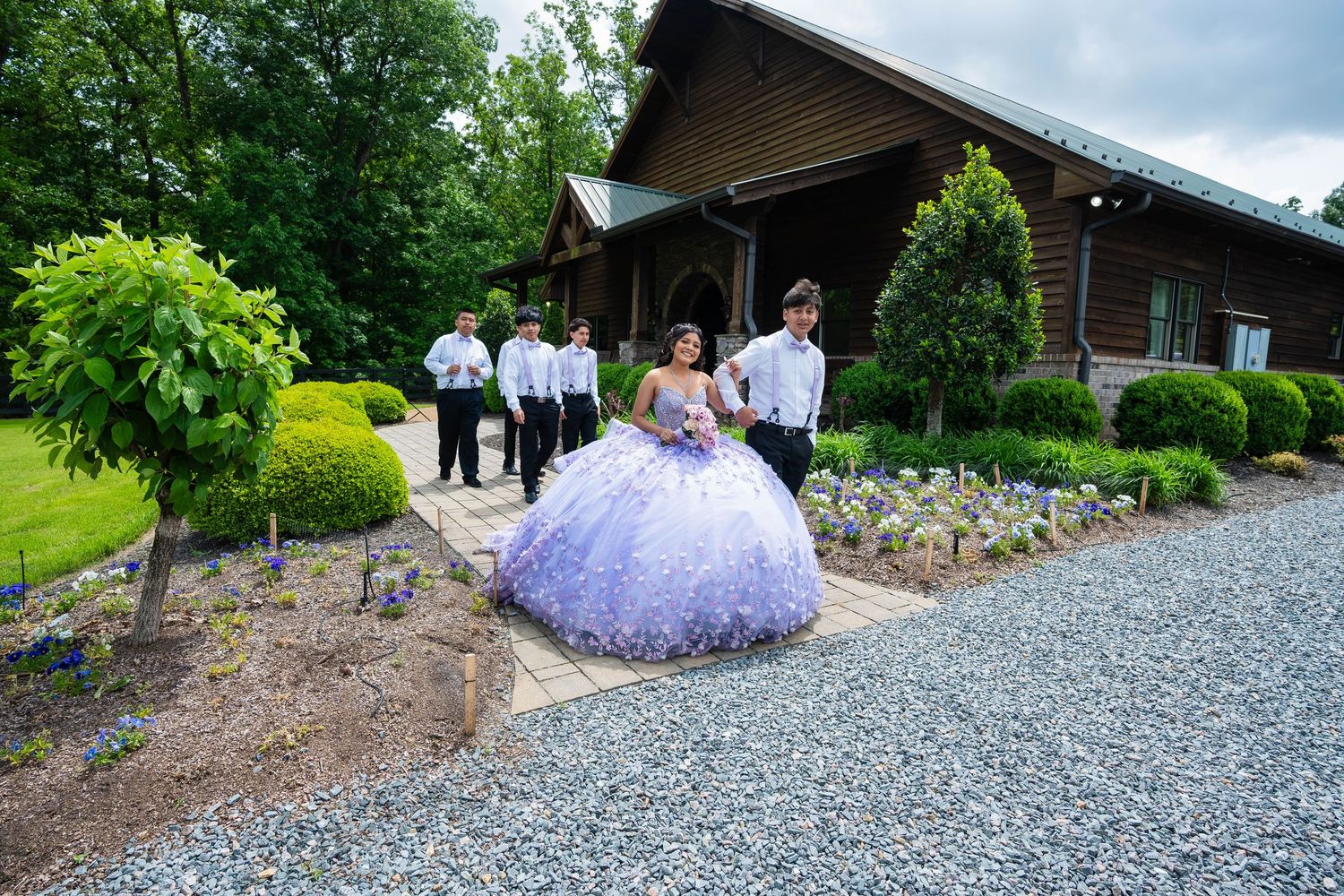 A stunning lavender quinceanera dress with intricate beading sparkles against a rustic stone archway backdrop.