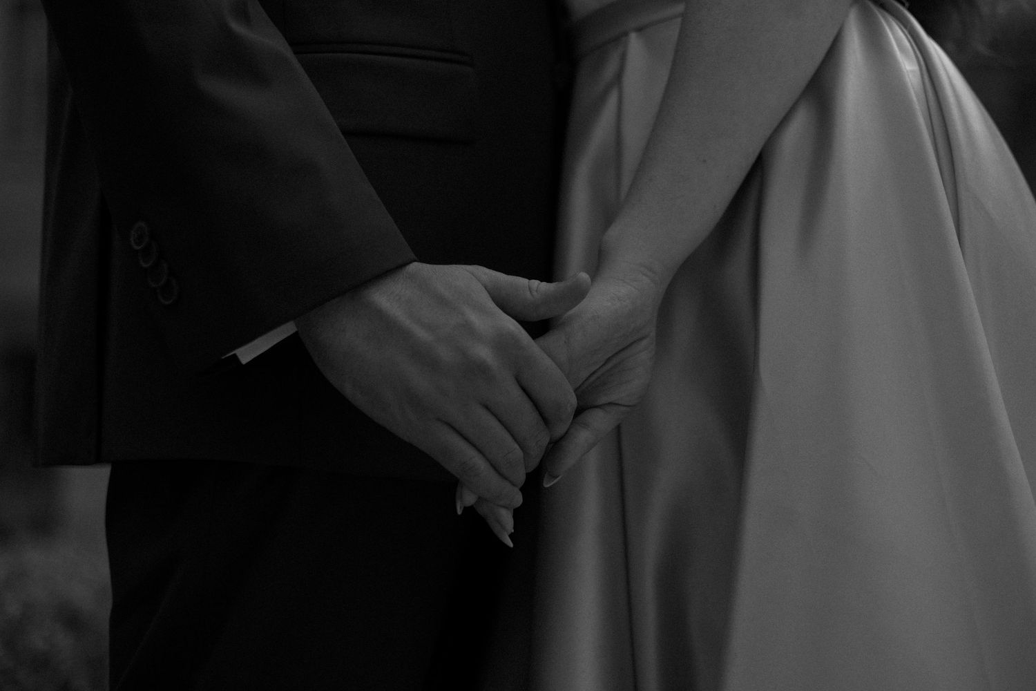 A couple in formal attire dancing intimately on a black and white dance floor during a romantic moment.