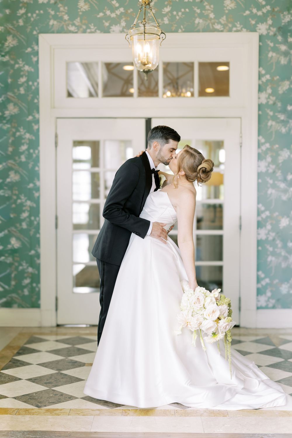 A romantic wedding photoshoot sequence showing a couple in formal attire sharing intimate moments against elegant floral wallpaper.