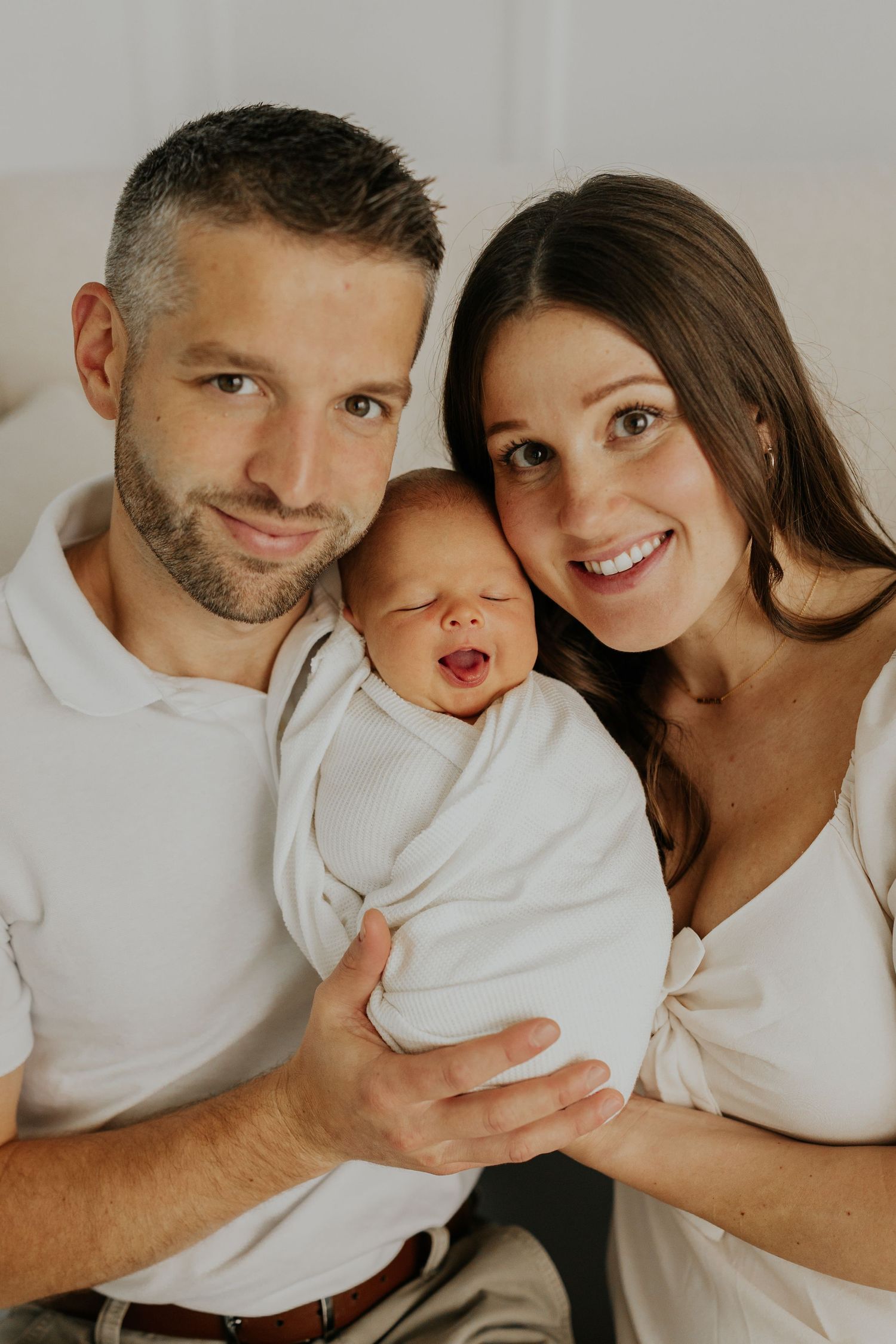 Happy family relaxes together in a series of candid shots with muted tones and warm smiles.
