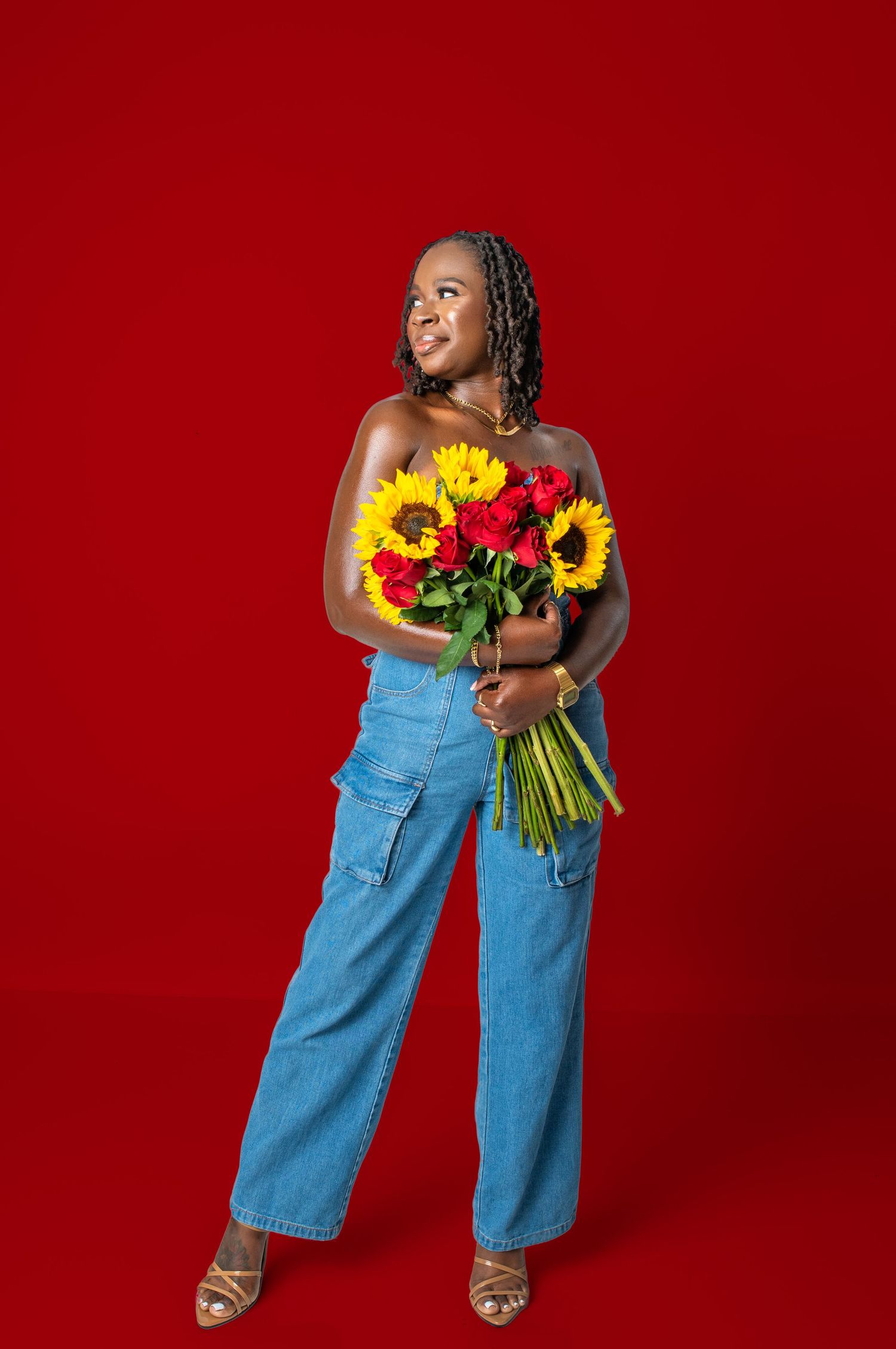 A person wearing denim overalls poses joyfully with sunflowers against a bold red backdrop in a dynamic photo series.
