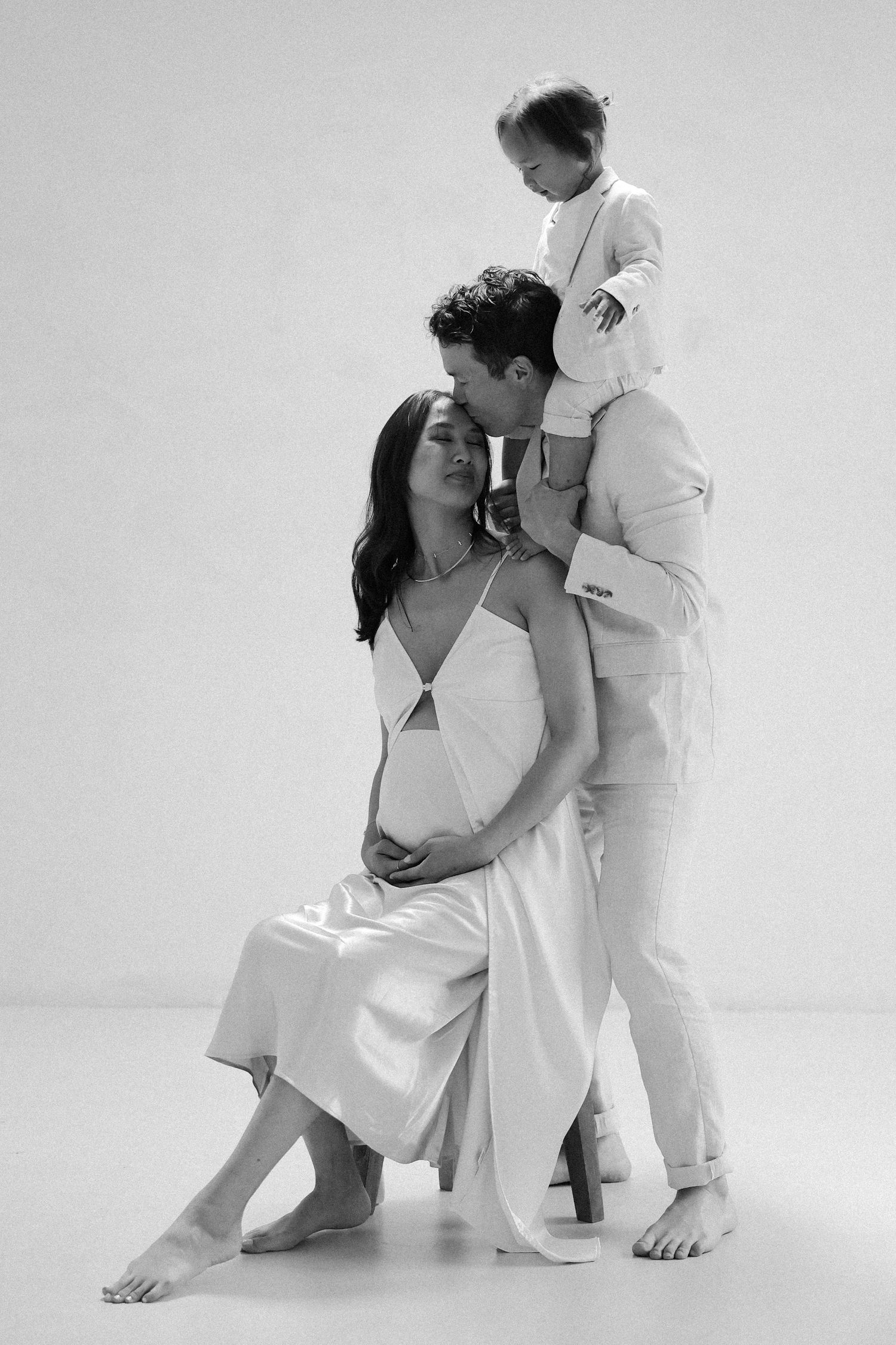 Minimal studio maternity photography with husband and toddler with mom in flowy dress
