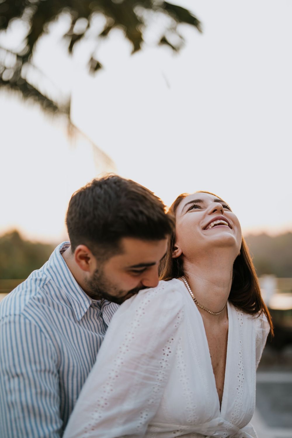 Candid laughing moment captured during a sunset engagement session.