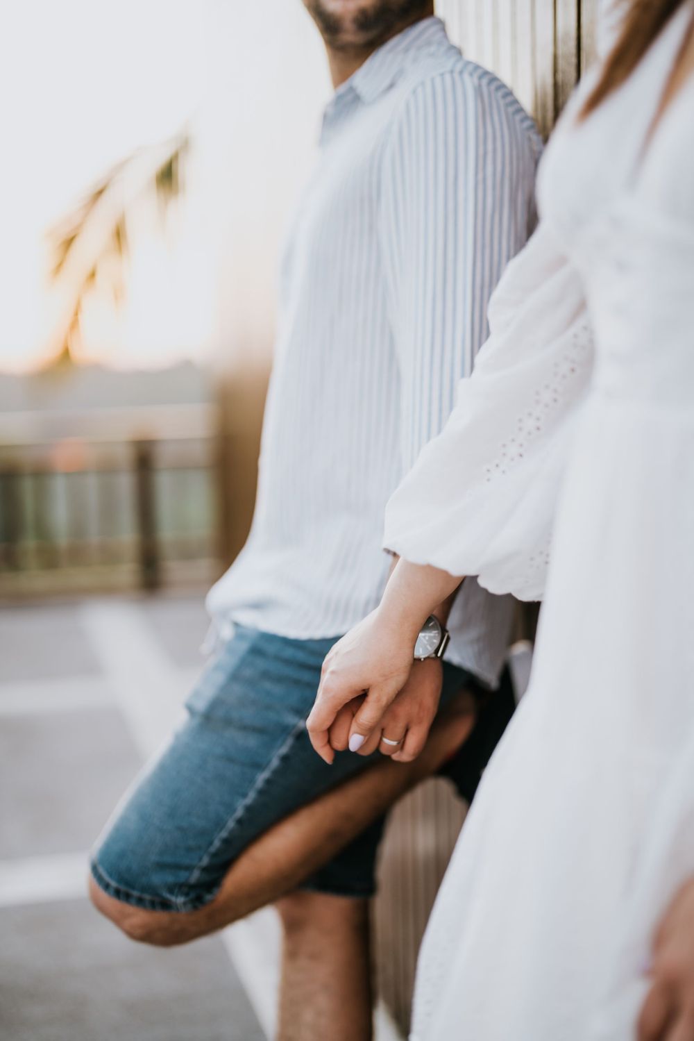 Detail shot of casual summer outfits in white and denim during an outdoor photoshoot.