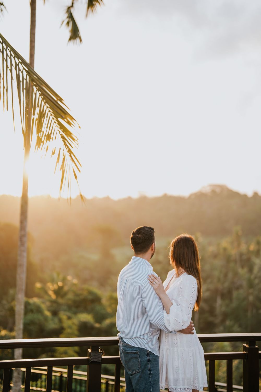 Intimate moment shared on tropical balcony during golden hour.