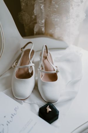 White bridal ballet flats arranged on a soft white fabric background. christchurch wedding photography
