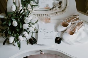 Elegant wedding details with high heel shoes, delicate white decorations, and greenery arranged on light surface. christchurch wedding photo