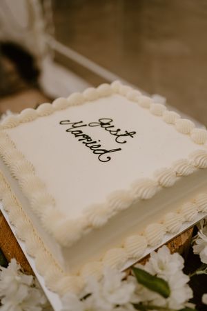 White wedding cake slices with elegant piped frosting borders displayed on a rustic table. christchurch wedding photography
