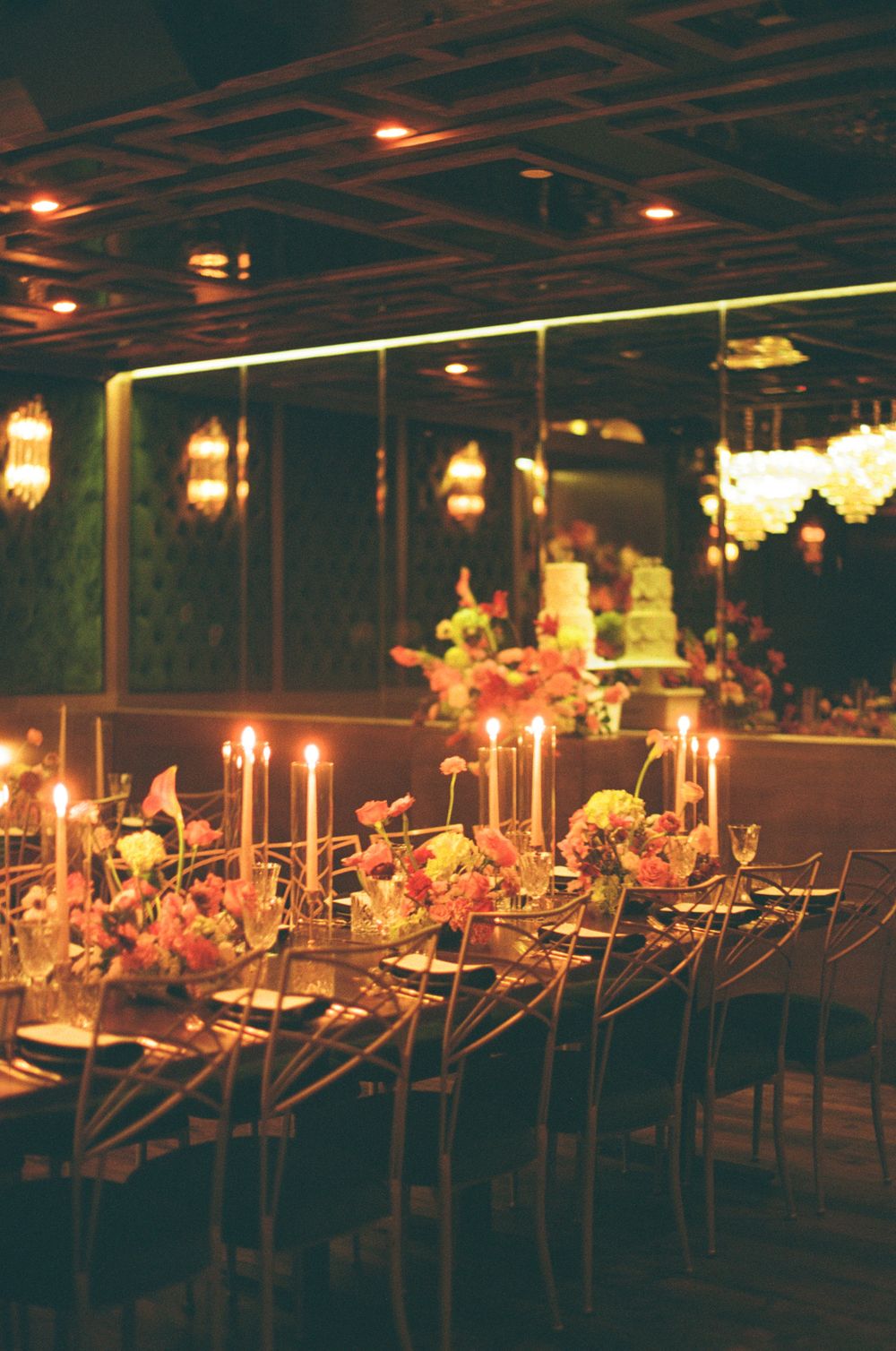 A dimly lit outdoor dining area at night with warm lighting and table decorations creating an elegant ambiance.