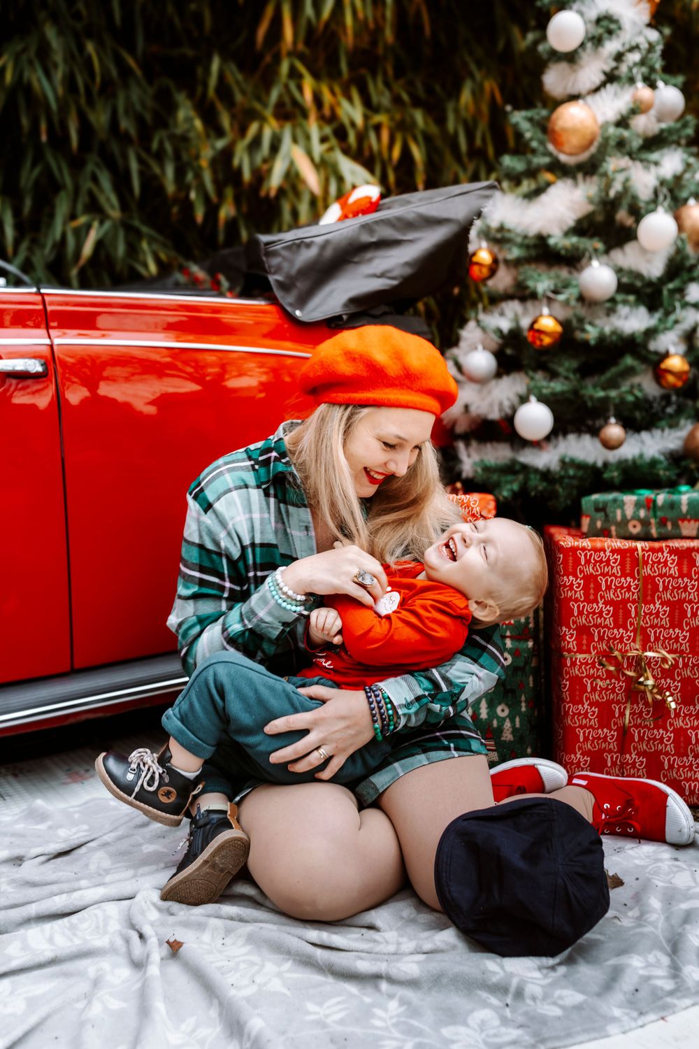 Mini-session photo de Noël 2024 avec une coccinelle VW rouge décorée pour les fêtes, créant une ambiance festive et chaleureuse.