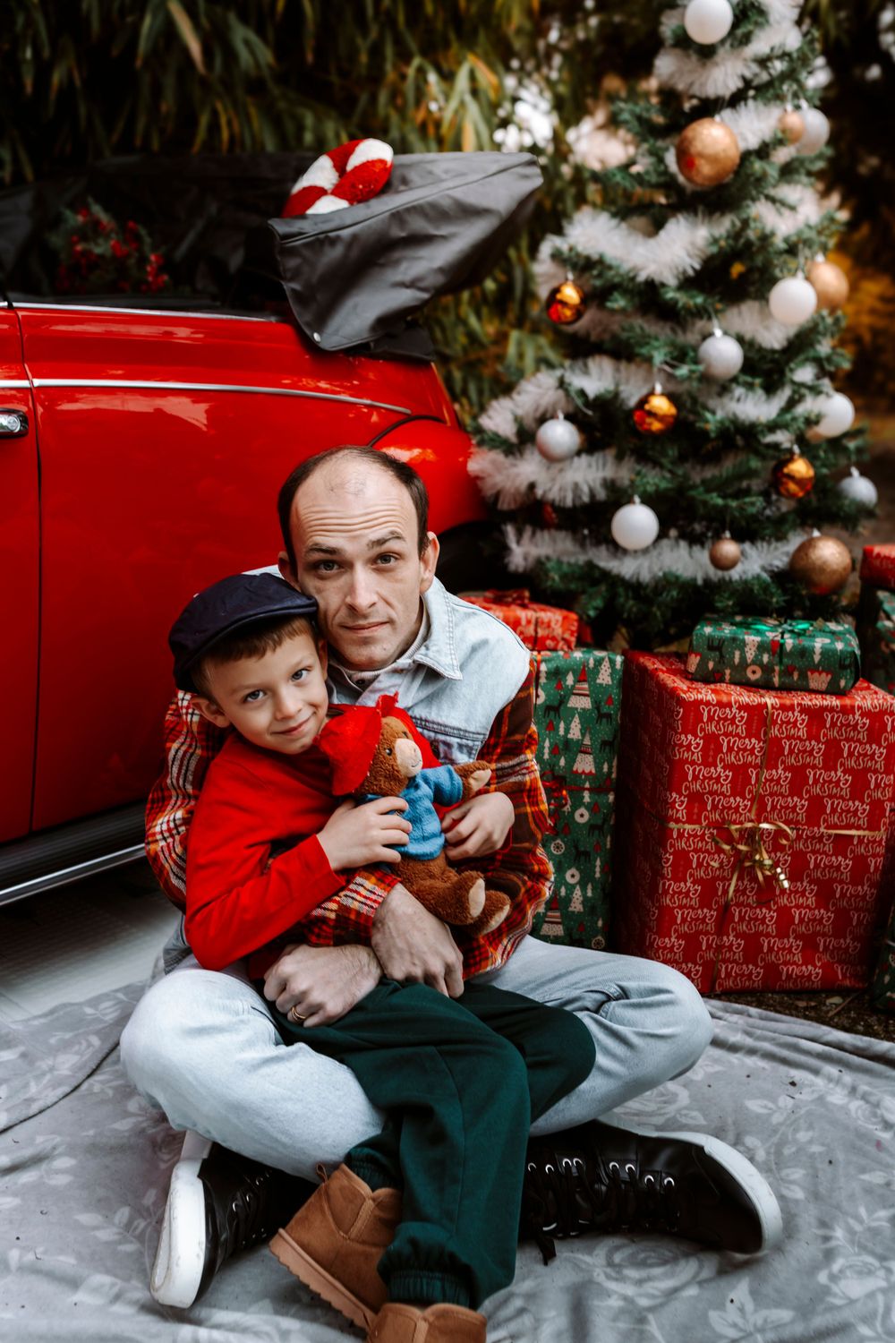 Mini-session photo de Noël 2024 avec une coccinelle VW rouge décorée pour les fêtes, créant une ambiance festive et chaleureuse.