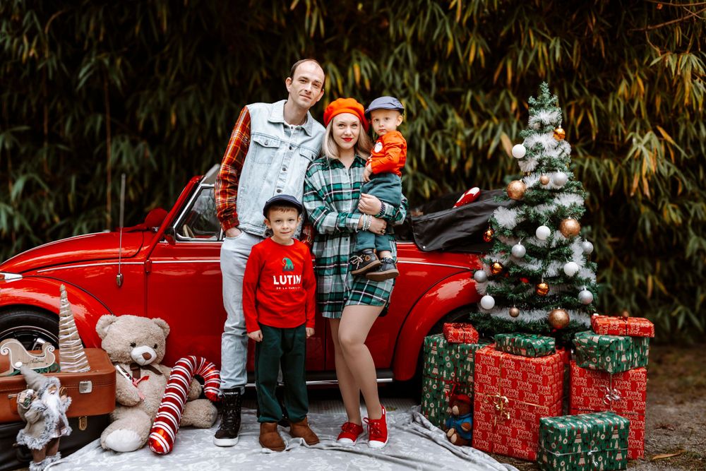 Mini-session photo de Noël 2024 avec une coccinelle VW rouge décorée pour les fêtes, créant une ambiance festive et chaleureuse.