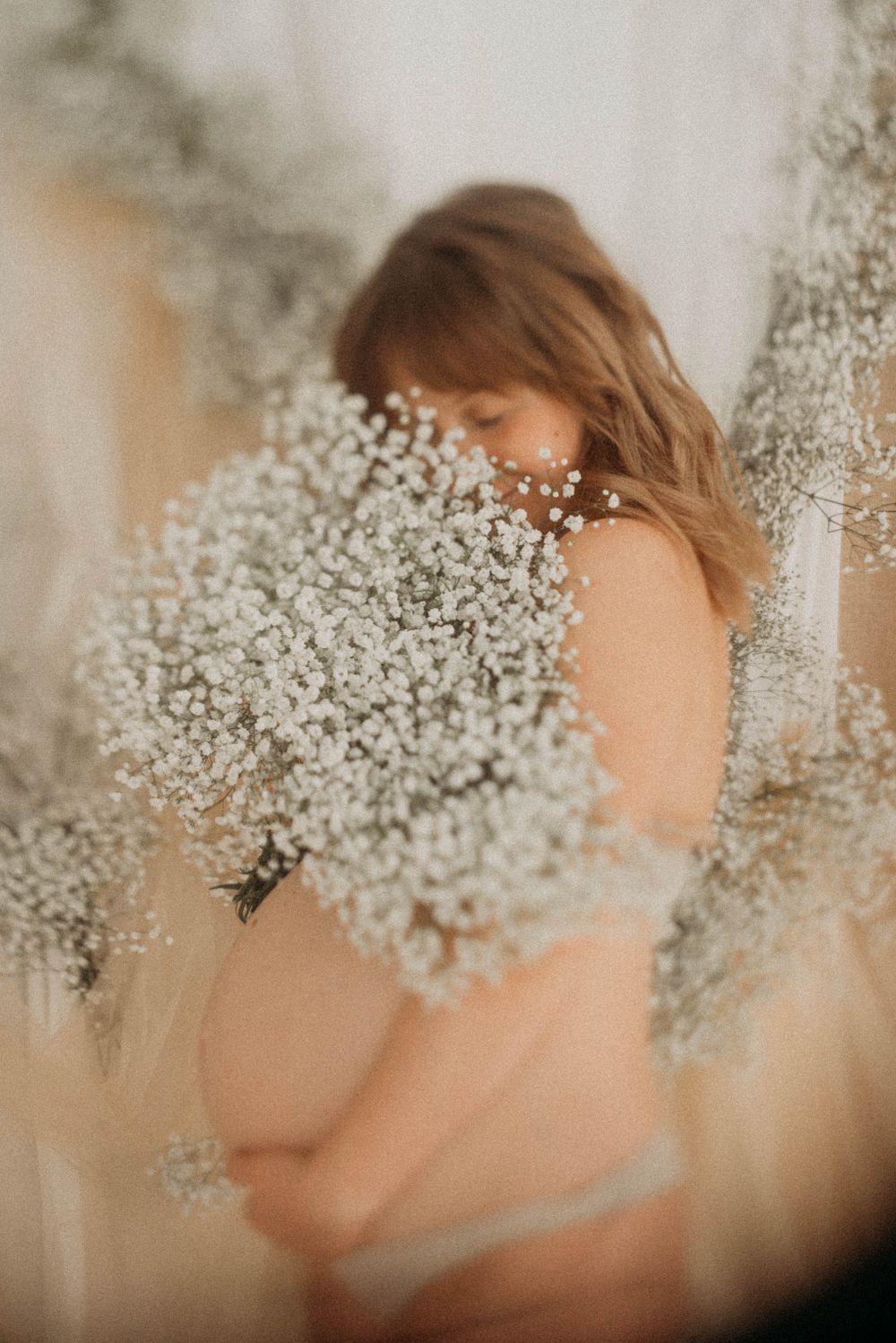 Artistic portrait with baby's breath flowers creating a dreamy overlay effect.