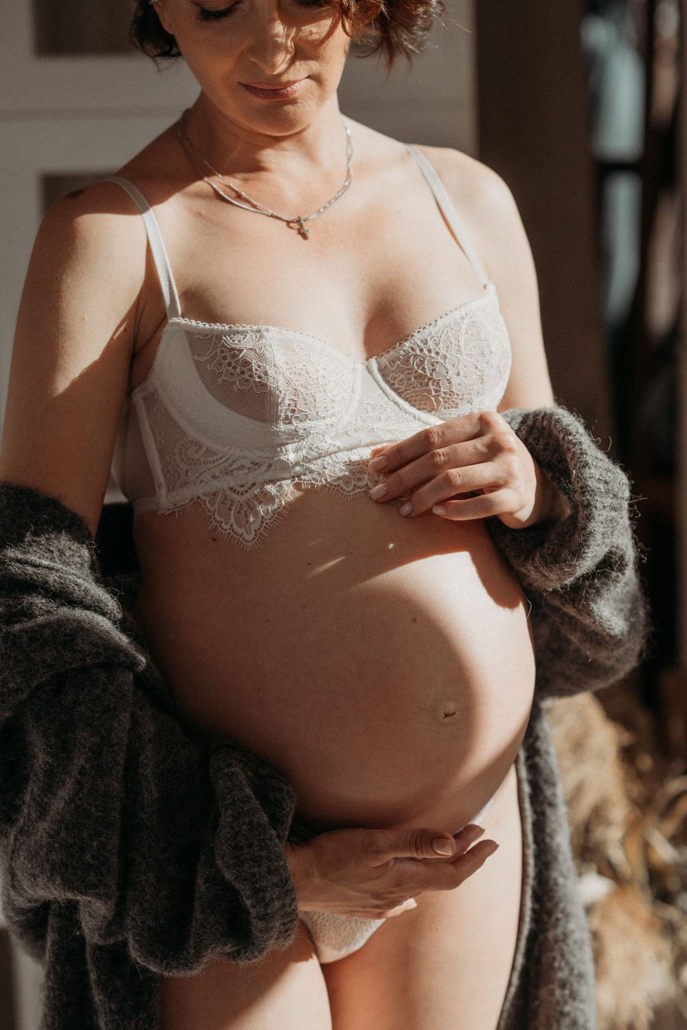Intimate boudoir photography featuring white lace lingerie and soft lighting.