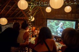 Wedding guests watch a slideshow at the reception