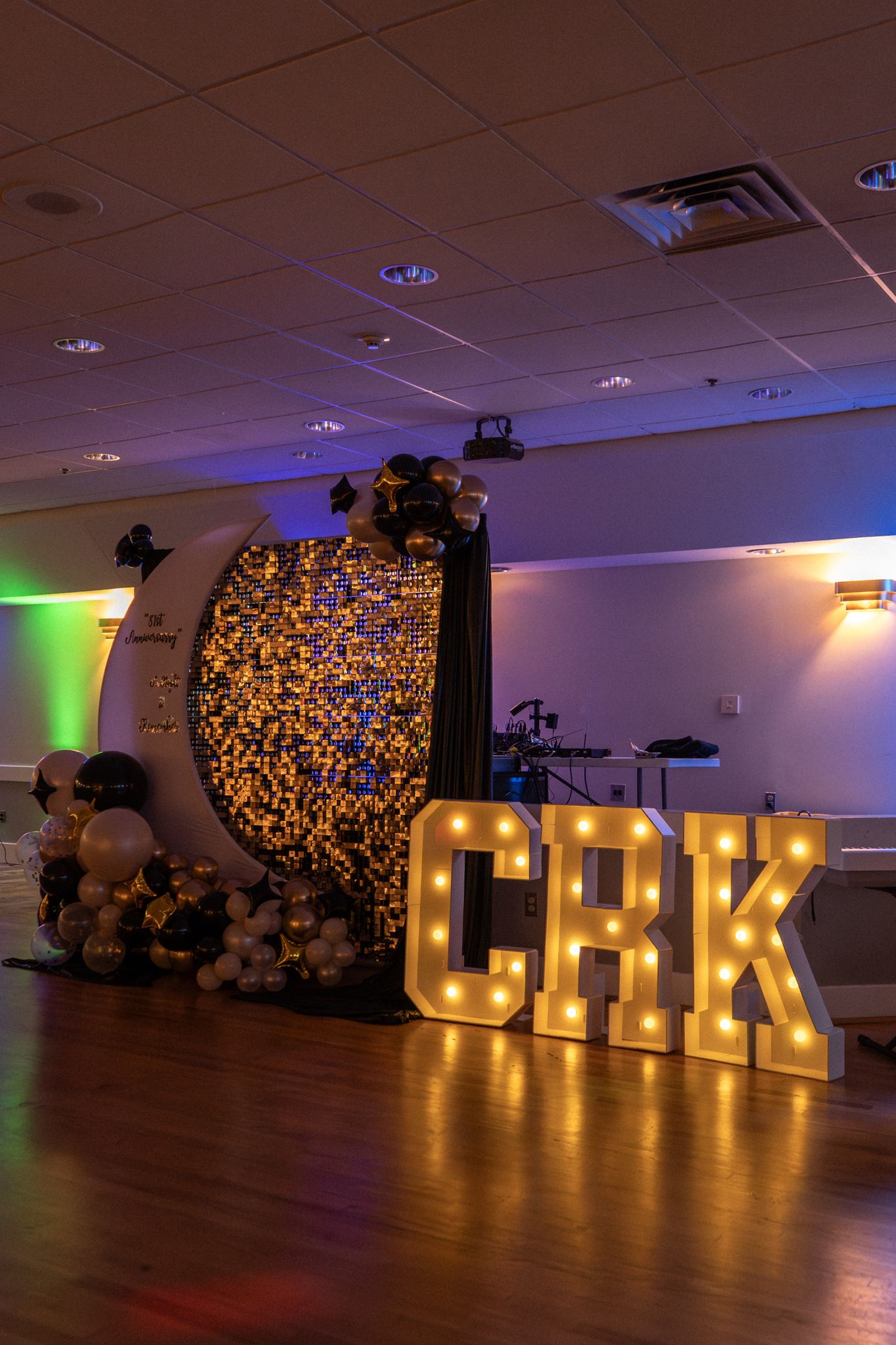 Large illuminated OHANA letters create a warm glow against a floral backdrop in an event space.