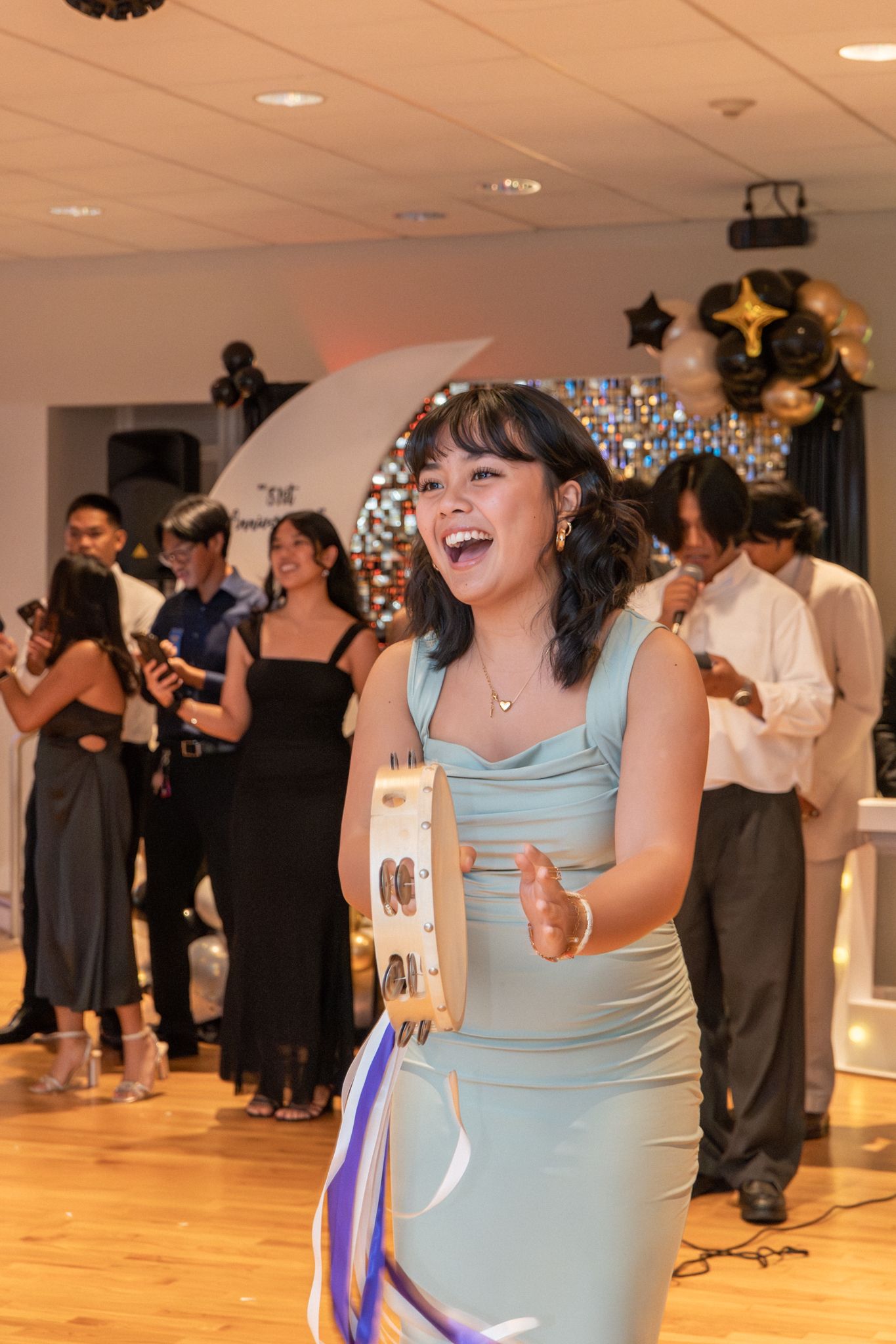 Guests enjoying themselves on a dance floor at an indoor event with people dancing in formal attire.