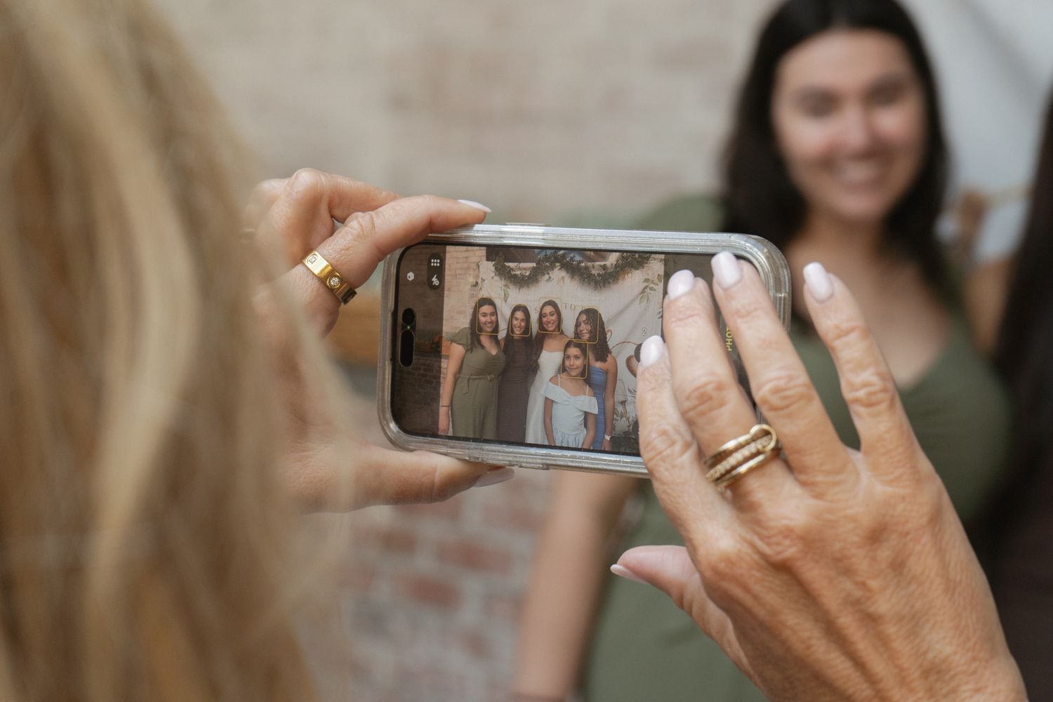 People take photos with smartphones at a gathering while hands hold up mobile devices to capture memories.