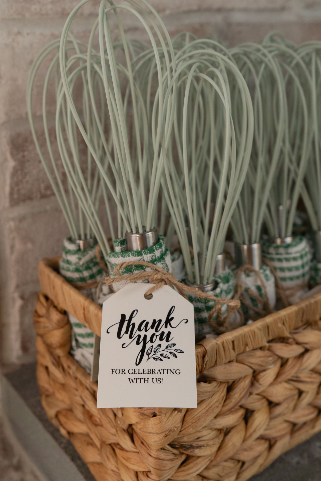 A series of decorative thank you tags displayed in a woven basket with dried air plants or Spanish moss.
