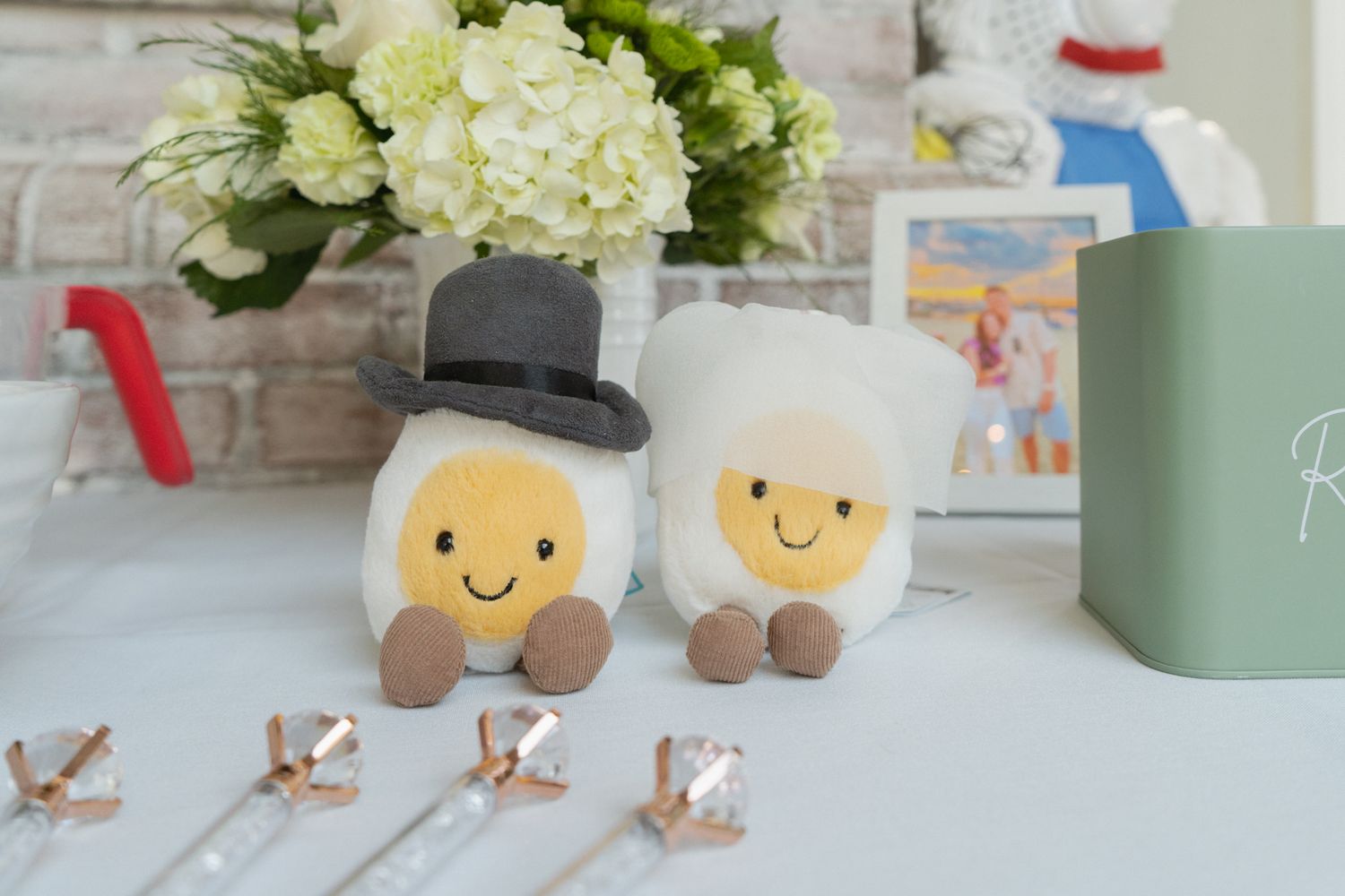 White hydrangea flowers and cute plush toys arranged on a shelf with decorative items in a bright interior setting.