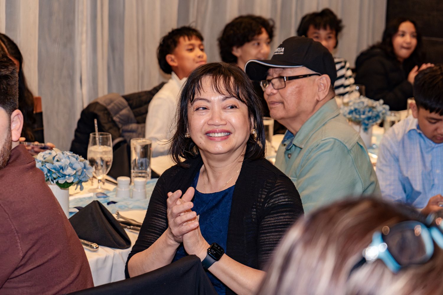 A group of people enjoying a social gathering at a dining event with tables and chairs.