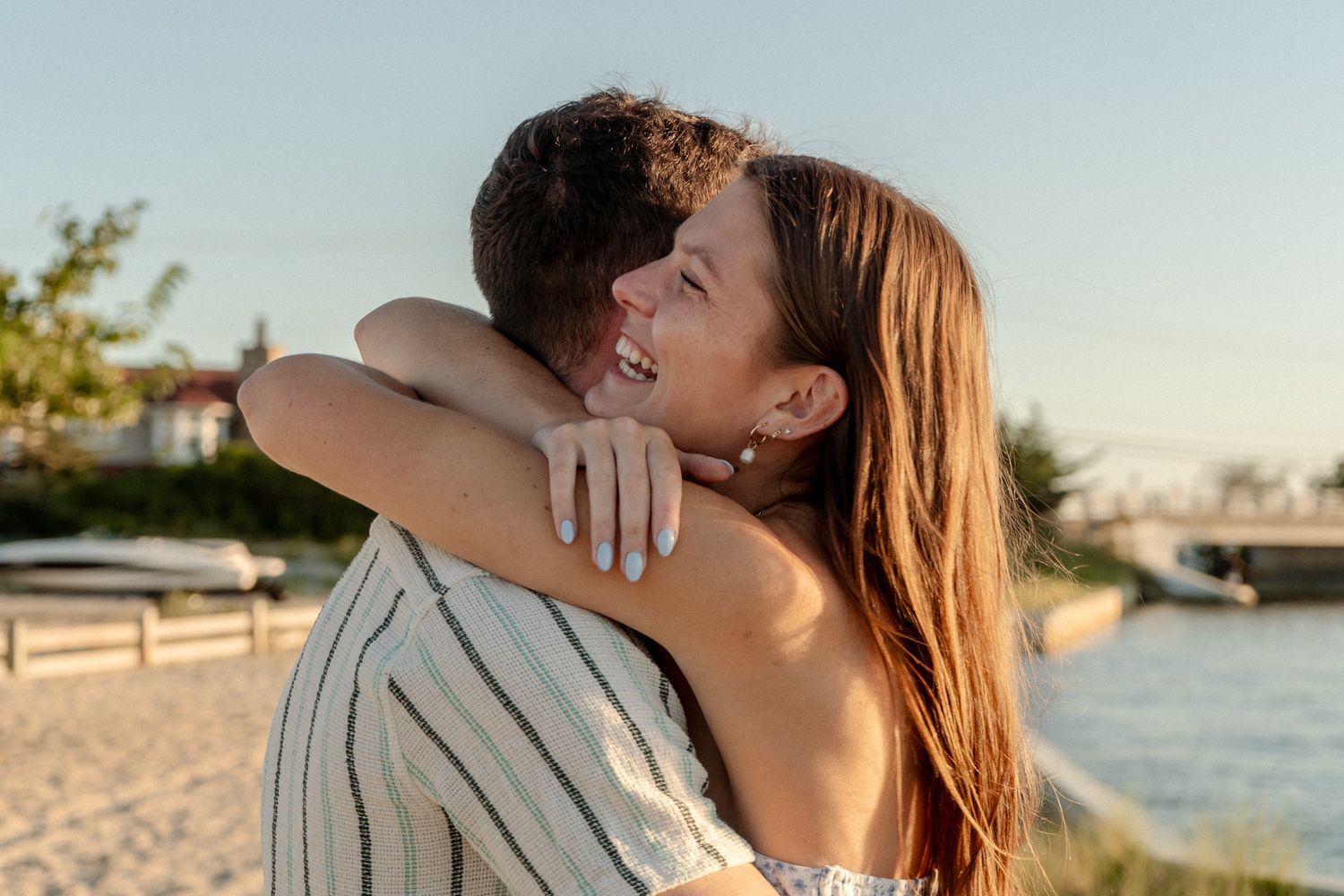 A tender embrace captured during golden hour on a sandy beach.