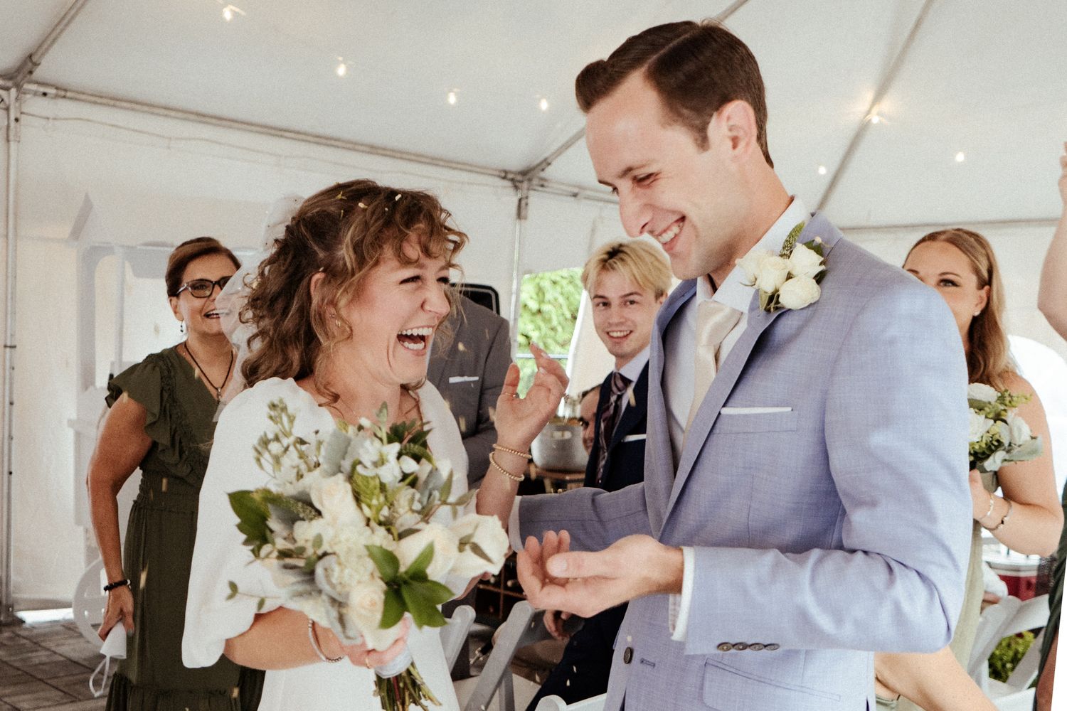 Wedding party members share joyful moments during an indoor celebration.