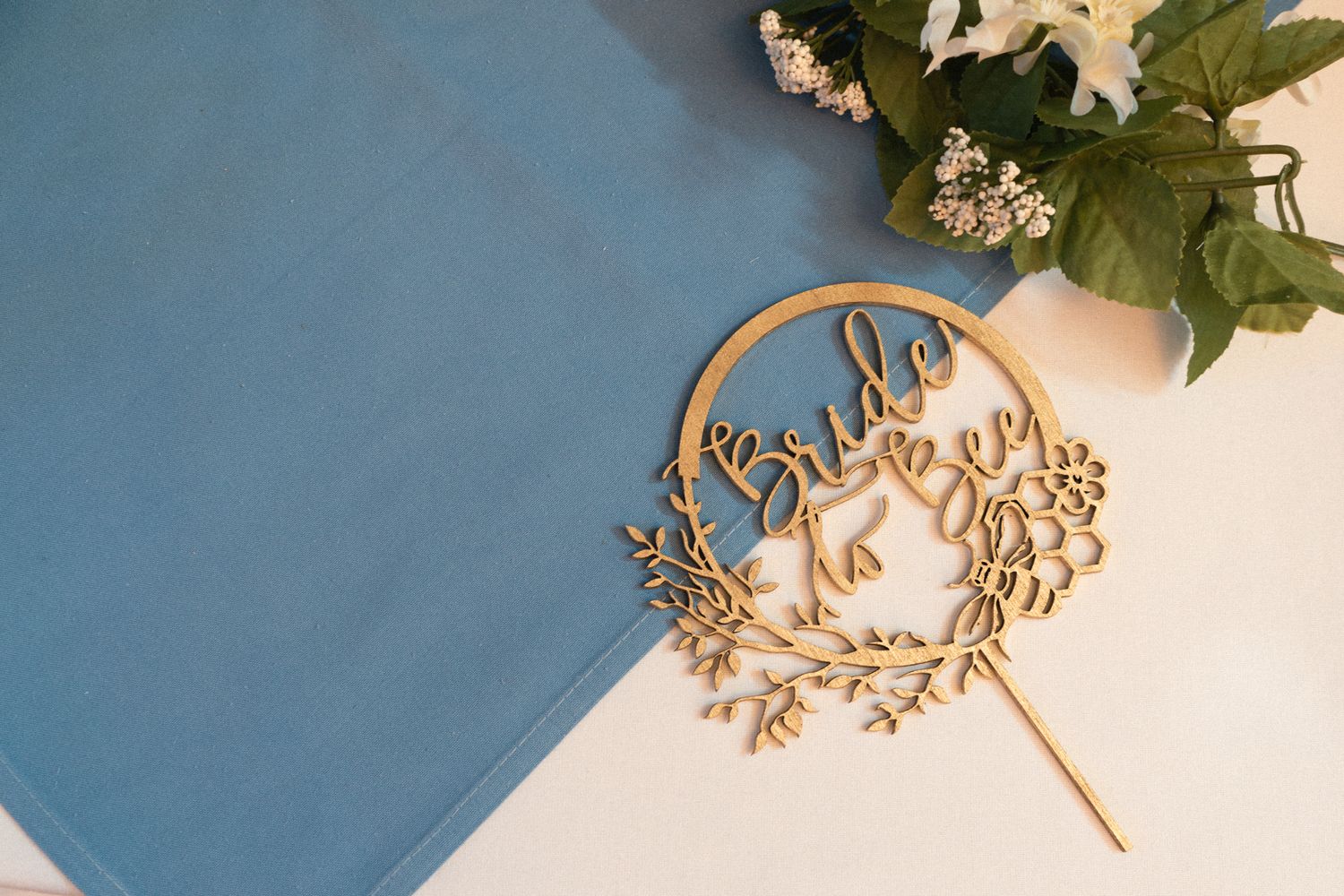 Decorative floral and leaf arrangement against blue background.
