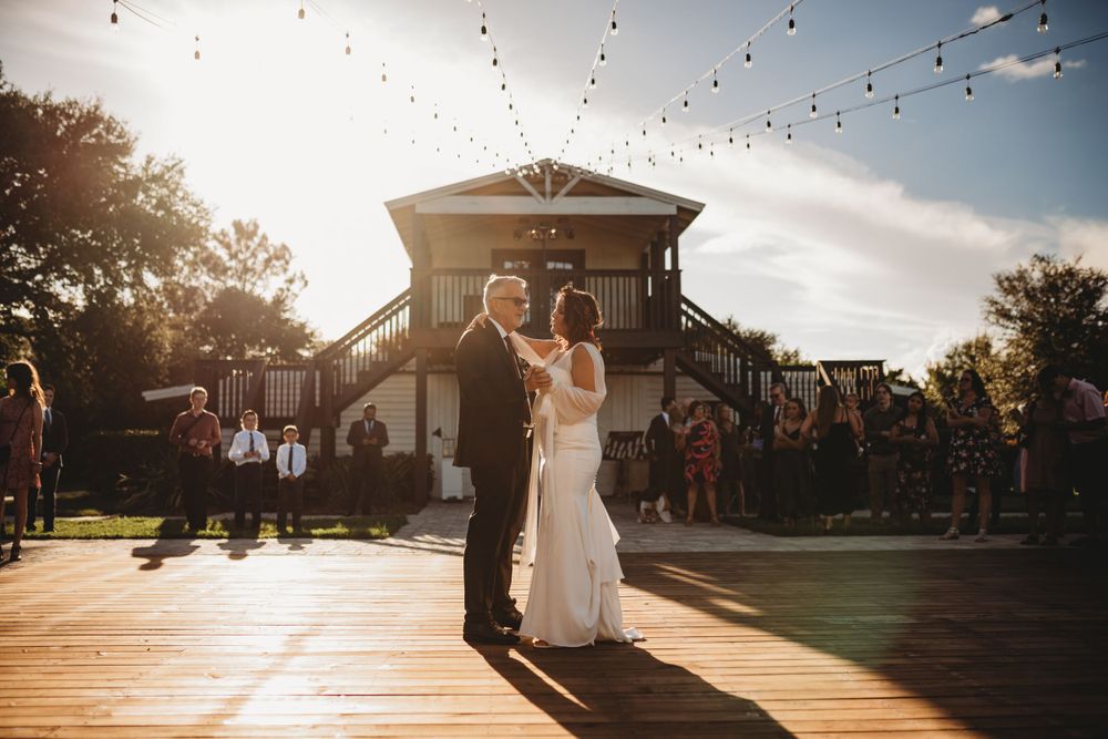 Sunset dance at an outdoor wedding venue with string lights overhead.