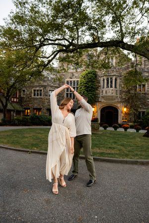 A couple dancing together in front of a stone building at dusk, captured in a series of romantic dance moves.