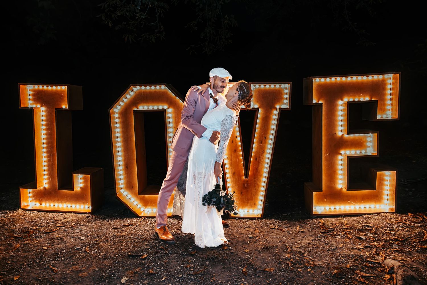 A romantic wedding photo series with illuminated LOVE letters in the background at night. Domaine des sources photographe de mariage