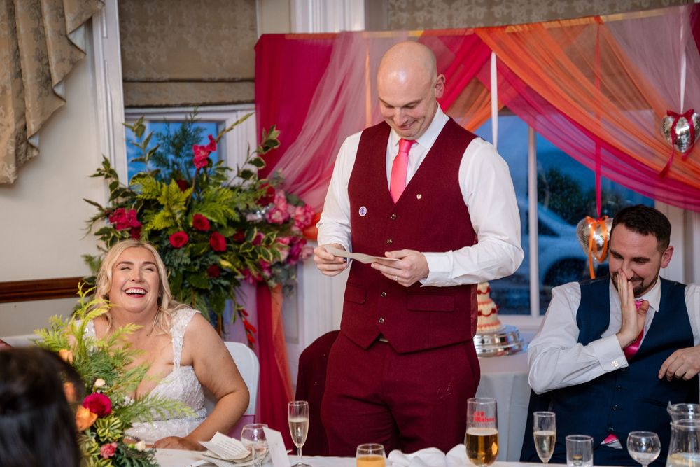 Wedding reception guests enjoying a celebration with colorful decor and dancing in a festive venue.