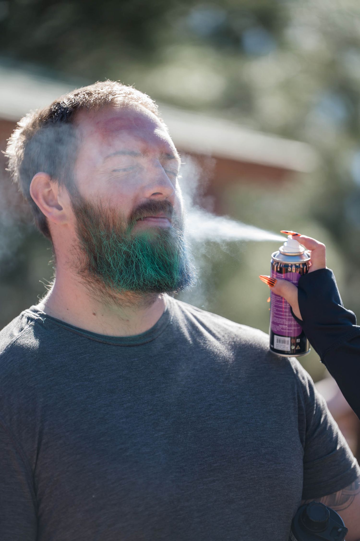 Person in gray shirt exhaling vapor from an e-cigarette device in a sequence of backlit photos.