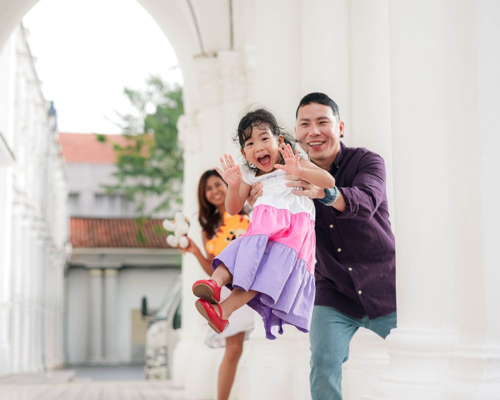 A series of five candid outdoor family photos showing joyful moments and playful interactions in casual settings.