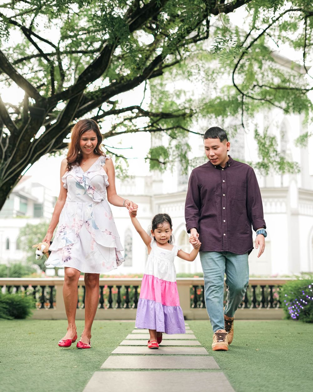 Family walking together and holding hands in a park on a sunny day, captured in multiple candid moments.