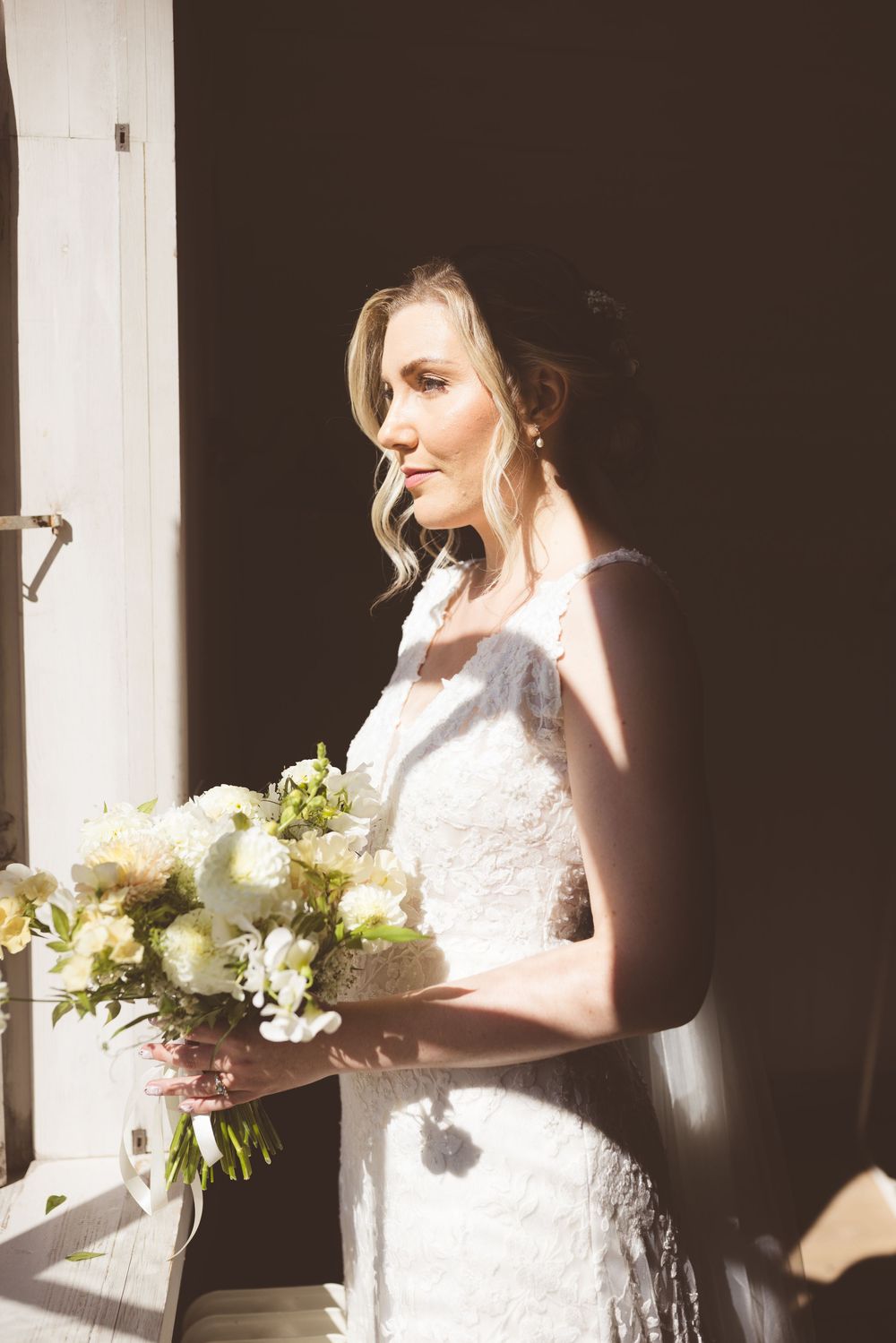 A series of artistic bridal portraits showing a person in a white dress holding a bouquet near a window with dramatic lighting.