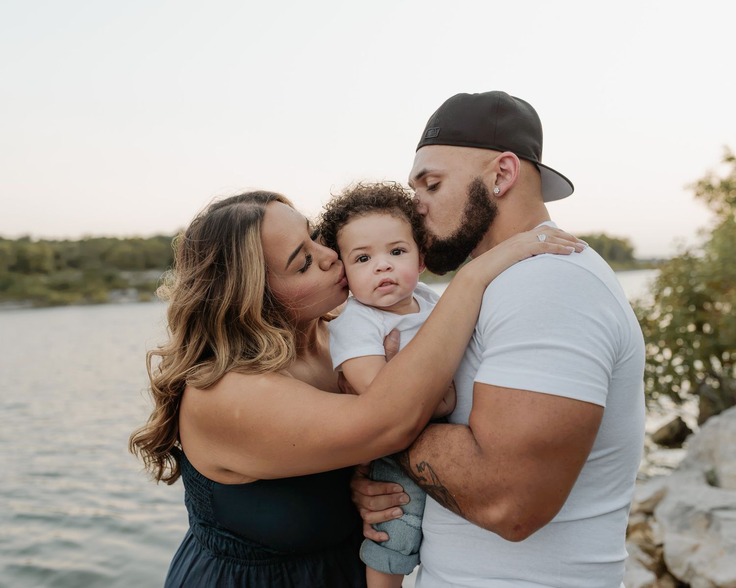 Parents holding smiling baby during golden hour session at Nolan Creek in Belton Texas