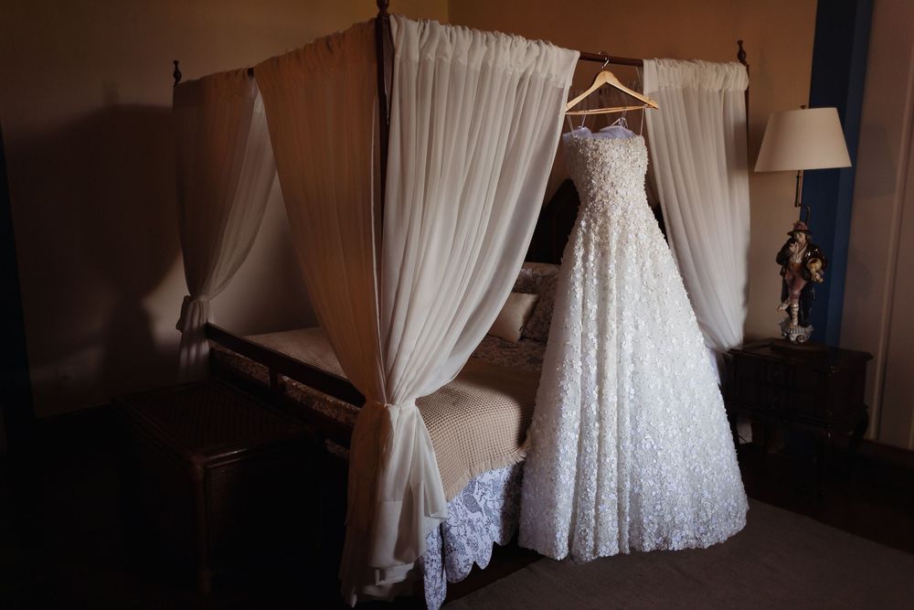 A collection of white wedding dresses hanging on display in a bridal boutique interior.