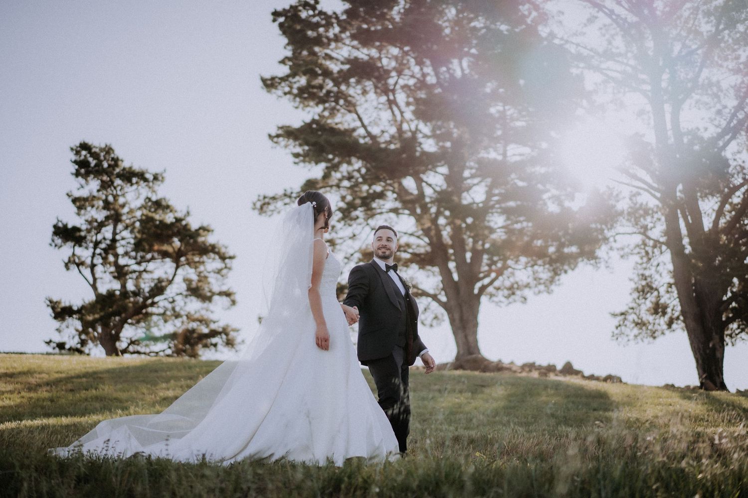 A romantic wedding photoshoot in front of a white building at sunset.