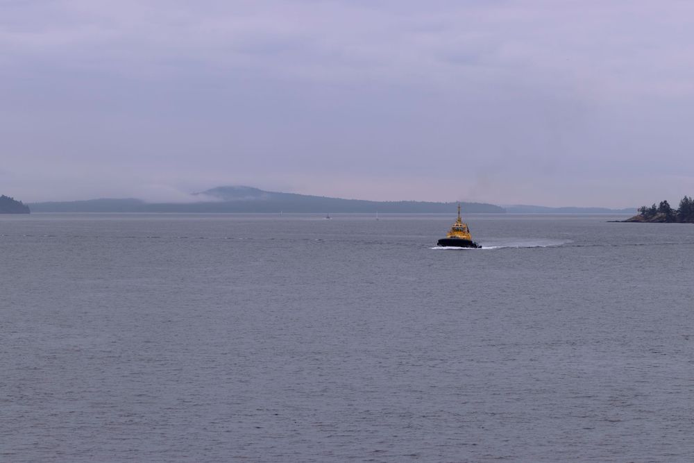 A series of panoramic images showing a foggy ocean landscape with mountains and a lighthouse in the distance.