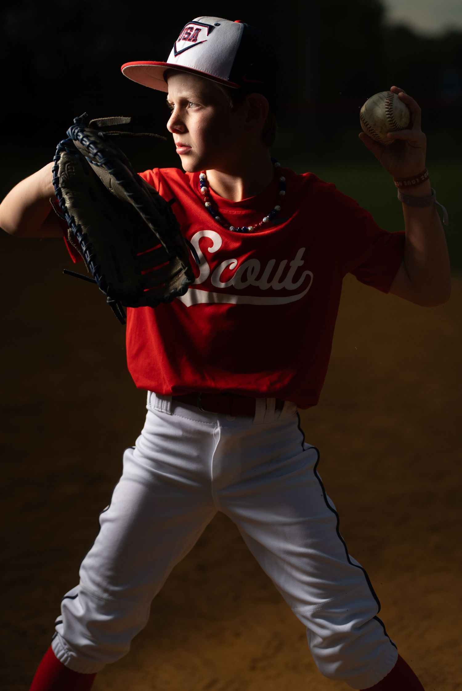 A baseball player in a red and white uniform demonstrates a pitching motion in a series of sequential action shots.